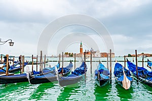 Venice, Italy. Empty Gondolas docked by lagoon mooring poles