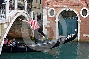 VENICE, ITALY/EUROPE - OCTOBER 12 : Gondolier plying his tradein Venice Italy on October 12, 2014. Unidentified people.