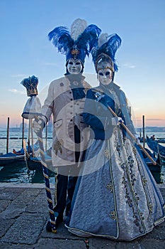 Couple in blue at the Carnival of Venice at dusk