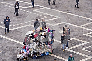 Venice Italy elevated day view of street vendor selling hats and carnival masks, with tourists on Saint Mark