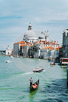 Venice, Italy. Gondola and tourist boats in Grand Canal. Basilica Santa Maria della Salute in background