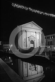 Venice, Italy, January 28, 2020 facade of a church in Venice at night with a canal in the foreground