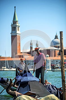 VENICE, ITALY - JULY 12 : Gondolier plying his tradein Venice Italy.