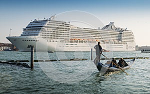 Juxtaposition of gondola and huge cruise ship in Giudecca Canal. Old and new transportation on the Venice Lagoon