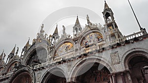 Venice, Italy - May 2019: Panorama of the west facade of St Mark`s basilica on Piazza San Marco. Rainy autumn weather