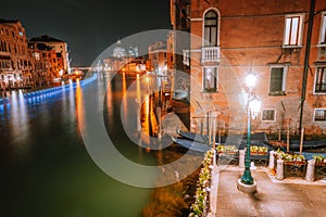 Venice, Italy night scenery of Grand Canal lit by lanterns and reflected on water surface. Majestic Basilica di Santa