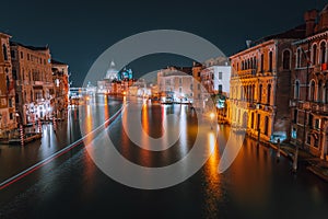 Venice, Italy night scenery of Grand Canal. Vivid light trails of ferries and boats reflected on water surface. Majestic