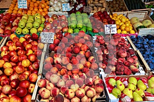 Venice, Italy - september 2016: Rialto fish markets. Fishmonger at work.Tablets with price of peaches and apples.