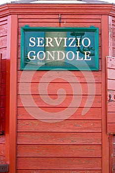 Venice Italy sign advertising Servicio Gondole (Gondola Service) with red wood background photo