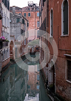 Typical canal scene in Venice with reflection in the water.