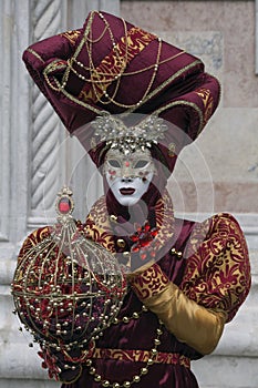 Venice masks dressed in in a beautiful red and gold costumes at the Venice Carnival held every February, Venice Italy