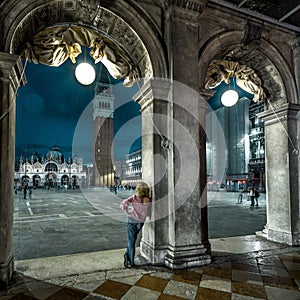 Venice at night, Italy. Young woman is on San Marco square in twilight