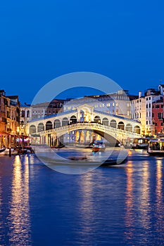 Venice Rialto bridge over Canal Grande with gondola travel traveling holidays vacation town portrait format at night in Italy