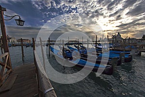 Venice's Santa Maria della Salute sunset view with row of gondola boats