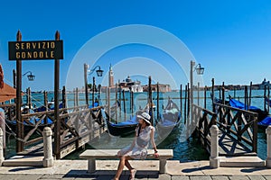 Venice - Tourist woman and sign indicating Gondola service at Saint Mark square