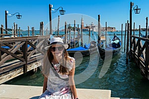 Venice - Tourist woman and swooden gondola boats at Saint Mark square