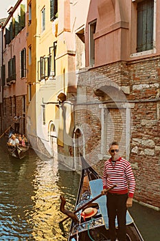 VENICE, VENETO, ITALY - Gondoliers and tourists, gondola riding, typical canal in Venice