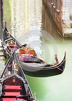 Venice vertical street view cityscape, Italy, Europe.Gondolas at their moorings close-up in water of small beautiful canal. Text