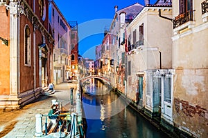 Venice view at night with canal, bridge and historical buildings