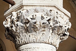 Venice, white capital sculpture with cherubs of Doge palace in Italy photo