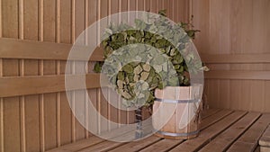 Vennik and wooden bucket in the sauna. Wooden bucket in the interiors of the bath. Sauna room with traditional sauna