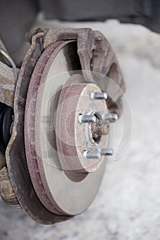 Ventilated brake disc on used car, removed wheel, selective focus