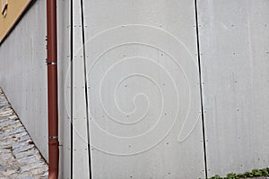 Ventilated facade from wood fiber cement board on plint wall of house