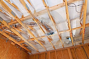 Construction workers install ventilation ducts insulation in residential building under renovation