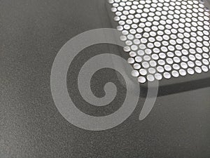 Ventilation grill in the computer. Metal surface with round numerous holes. Copy space