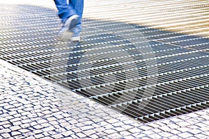 Ventilation iron grid on urban area with stone road - image with copy space