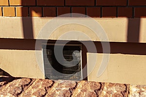 Ventilation outlet closed by grille. Red bricks wall. photo