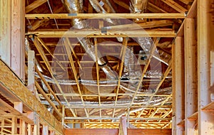 Ventilation pipes in silver insulation material hanging from the ceiling inside new building