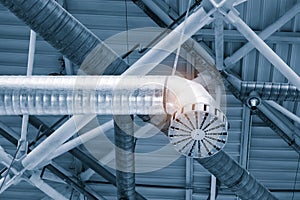 Ventilation pipes in silver insulation material hanging from the ceiling inside new building