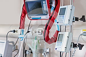 Ventilators and vital sign monitors next to Intense Care Unit bed