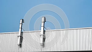Vents and roof of Factory or warehouse building in industrial estate with blue sky and copy space