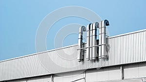 Vents and roof of Factory or warehouse building in industrial estate with blue sky and copy space