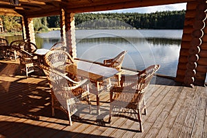 The veranda of a wooden house on which there are a table and chairs for relaxing.