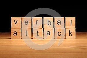 Verbal attack words written on wood cube photo