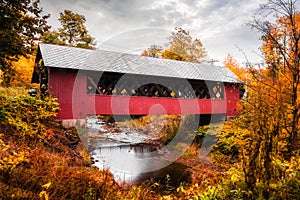 Vermont covered bridge surrounded by colorful fall foliage.