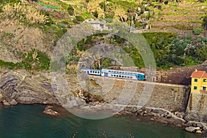 Scenic nature landscape in Cinque Terre. The passenger train enters the tunnel.