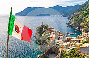 Vernazza village colorful houses, Castello Doria castle on rock cliff and italian flag foreground, Genoa Gulf, Ligurian Sea, Natio