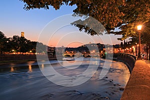 Verona cityscape with Ponte Pietra on Adige river with historical buildings in the evening