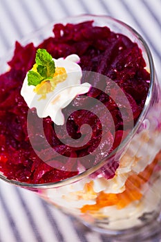 verrin with salad herring under fur coat from vegetables on striped tablecloth