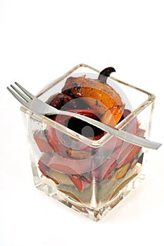 Verrine of candied peppers with fork close-up on white background