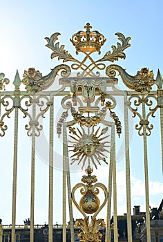 Versailles, Paris, France, June 30, 2022. Gorgeous detail of the golden gate of the royal palace. The late afternoon light