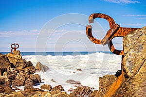 Vertic shot of the Peine del Viento sculptures of Eduardo Chillida at the beach in Spain photo