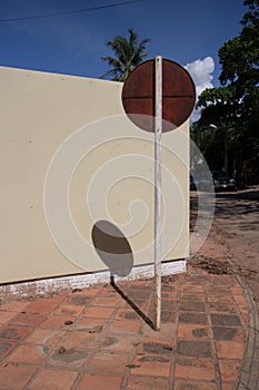 Vertical abstract view of round sign on a pole on a sunny corner