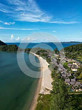 Vertical aerial of Koh Chang Beach Villas with grey roofs at a turquoise coastline in Thailand