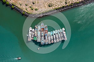 Vertical aerial view of freighter ships moored in the harbor entrance of Port Louis.