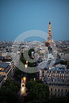 Vertical aerial view of the glowing Eiffel Tower over the skyline of Paris, France